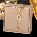 Detailed shot of golden square alphabet G pendant necklace on a premium leather jewelry box - Letter G-Gold