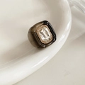 Détail d'une bague vintage en résine avec grand cristal posée sur un plat en céramique - Noir & Cristal Transparent