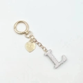 Close-up of golden letter L keychain pendant with rhinestones and heart tag - Letter L