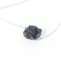 Macro shot of irregular natural grey crystal pendant with sleek silver link chain - Smoky Quartz