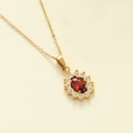 Macro shot of gold sunburst pendant with red oval stone and white zircon accents - Gold/Red Stone (Oval Flower)
