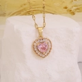 Golden heart necklace with pink gemstone and zircon pendant on textured stone - Pink