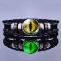 Detailed macro of woven leather bracelet with luminous green dragon eye glass cabochon - Yellow-Green Luminous Eye Style