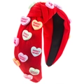 Dettaglio della fascia rossa annodata con ciondoli a cuore colorati e scritte dolci - Rosso