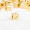 Macro shot of 18K gold plated cube bead with zircon inlay and checkmark pattern - Checkmark Symbol Pendant