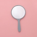 Mini round handheld makeup mirror with grey plastic handle on pink background - 5.5x10cm / Light Blue