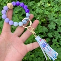 Close-up of beaded keychain bracelet with floral PU leather tassel and wood beads - Floral Printed Tassel Purple Marble Beaded (款30)