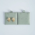 Detailed view of floral earrings with pearl tassels on green velvet jewelry pads - Light Green