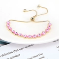 Detail view of pink evil eye bracelet with golden chain and adjustable zircon clasp - Pink