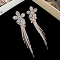 Detailed macro view of French style floral earrings with sparkling tassels and crystals - White Shell Flower Silver Tassel Style