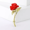 Elegante spilla a rosa rossa con stelo e foglie in metallo dorato su sfondo bianco - Rosso