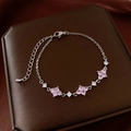 Detalle de pulsera de trébol plateada con piedras rosas en un joyero de lujo - Estilo Trébol Rosa de Plata con Circón