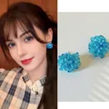 Nahaufnahme von blauen Perlenohrsteckern im Blumen-Design mit künstlichen Blütenblättern - 36# Silbernadel - Denimblau