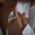 Anillo dorado grueso de diseño minimalista con acabado pulido en la mano de un modelo - US 7 / Dorado