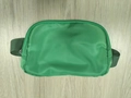 Grass green nylon belt bag with adjustable dark green strap on wooden background - Green