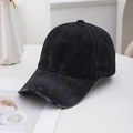 Dettaglio del cappellino in denim nero lavato con tesa consumata su scrivania moderna - Nero