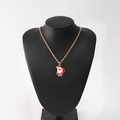 Golden necklace with red and white enamel Santa Claus pendant on a black neck display - Santa Claus