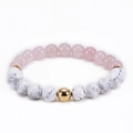Detail of pink crystal and white marble beads with a gold spherical accent bead - Howlite