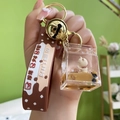 Acrylic bubble tea bear keychain with liquid sand and golden bell charm detail - Doll Box + Silicone Strap Style