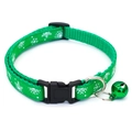 Close-up of green nylon pet collar with white snowflake patterns and a green metal bell - Dark Green Snowflake