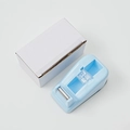 Light blue plastic tape dispenser with serrated blade and white packaging box - Blue