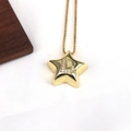 Macro detail of star pendant with sparkling letter L inlay on a gold cross chain - Letter L
