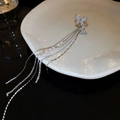 Close-up of butterfly ear cuff with sparkling tassels and delicate white pearls - Silver Left Ear Butterfly Ear Cuff
