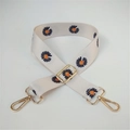 Detail view of adjustable canvas shoulder strap with orange daisy pattern and gold hardware - No. 13 White Black Orange Floral