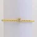 Detailed macro view of gold beaded bracelet featuring a sparkling zircon paved letter G charm - Letter G