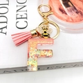 Detail of resin letter F keychain with golden bee charm and pink leather tassel decoration - Letter F Bee Keychain