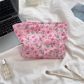 Pink floral quilted cosmetic bag with sozakka tag on a cozy white bed linen setting - Lusi Portrait