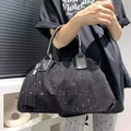 Detalle de bolso tote negro con pedrería brillante, asas de cuero y colgante de borla - Negro