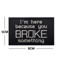 Detail view of 8x5cm black embroidered patch with motivational quote lettering - I'M HERE BECAUSE YOU BROKE SOMETHING / Black with White Letters