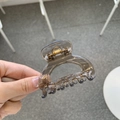 Detail of a brown translucent square hair claw clip with a minimalist geometric lock design - Transparent Brown