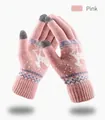 Close-up of pink winter knit gloves with reindeer pattern and gray touchscreen fingertips - Pink