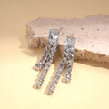 Vue détaillée des boucles d'oreilles argentées à pampilles avec zircons géométriques - Boucles d'Oreilles à Gland en Aiguille d'Argent / Argenté