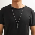 Détail d'un pendentif boussole et épée vintage sur une chaîne masculine en acier - Épée de Gouvernail