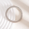 Gros plan d'un bracelet spirale argenté texturé sur un support minimaliste crème - Bracelet à texture de bobine enveloppée d'argent (L714-1)