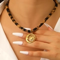 Detail einer Boho-Halskette mit Leopardenmuster-Band und goldenem Sonnen-Mond-Anhänger - Sonne und Mond Halskette (WG-0430)