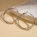 Detail shot of silver double-hoop geometric earrings on a white natural stone base - 50mm / Silver