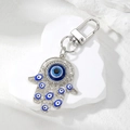 Close-up of silver Hamsa Hand keychain with blue Evil Eye and sparkling rhinestones - Silver with Royal Blue Eye Style