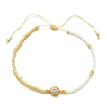 Close-up of golden and white seed bead bracelet with crystal charm and adjustable cord - White