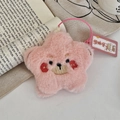 Detailansicht eines rosa Plüsch-Sternanhängers mit Stickerei auf einem offenen Buch - Kleiner Fuchs (Rosa)