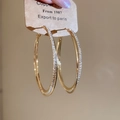 Detailansicht der goldenen Kupfer-Creolen mit schimmernden, pavé gefassten Zirkoniasteinen - Creolen - Gold