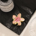 Pink and peach gradient frangipani hair claw clip with golden metal finish on dark backdrop - Pink