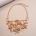 Detail of layered gold necklace with starfish charms, conch shell and faux pearls - Necklace - Gold
