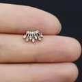 Dettaglio di un piercing a corona in argento con zirconi cubici tenuto in mano - Corona Squisita