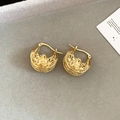 Macro shot of gold-plated hollow floral earrings on a textured grey background - Ear Clip - Gold (Real Gold Plated)