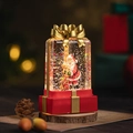 Boule à neige de Noël en forme de cadeau avec Père Noël et un nœud doré brillant - Rouge - Père Noël