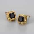 Macro shot of gold square earrings featuring black zircon center and pavé diamond halo - Gold Black